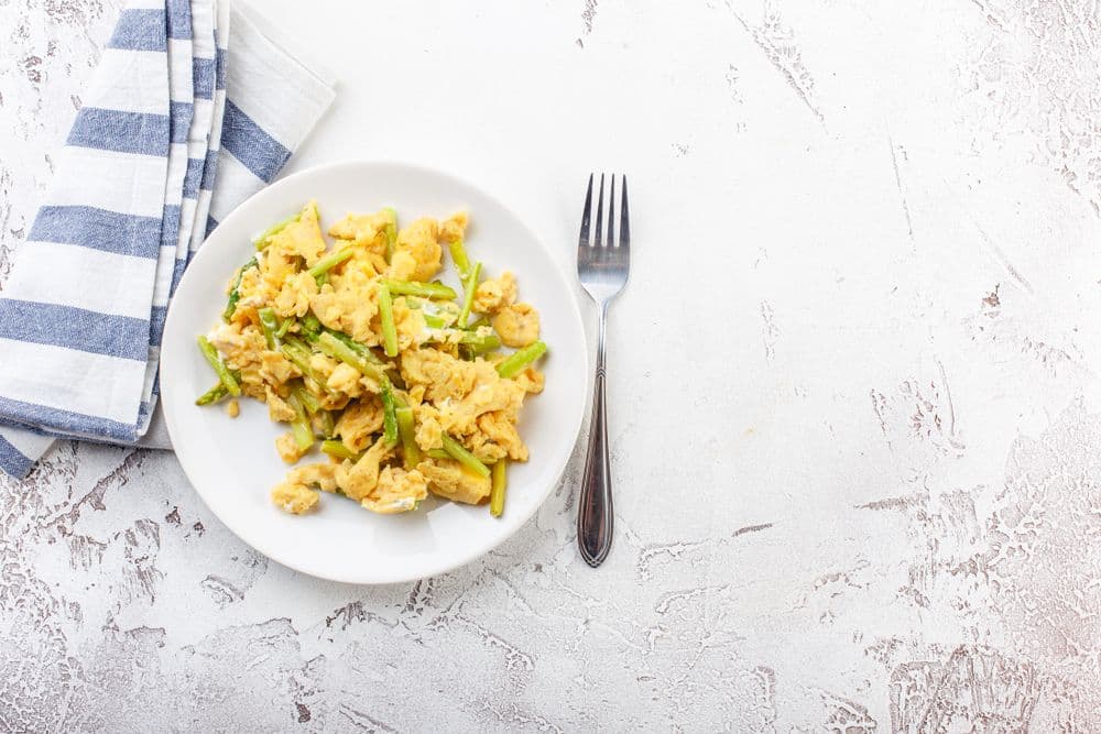 Oeufs brouillés sur asperges roties